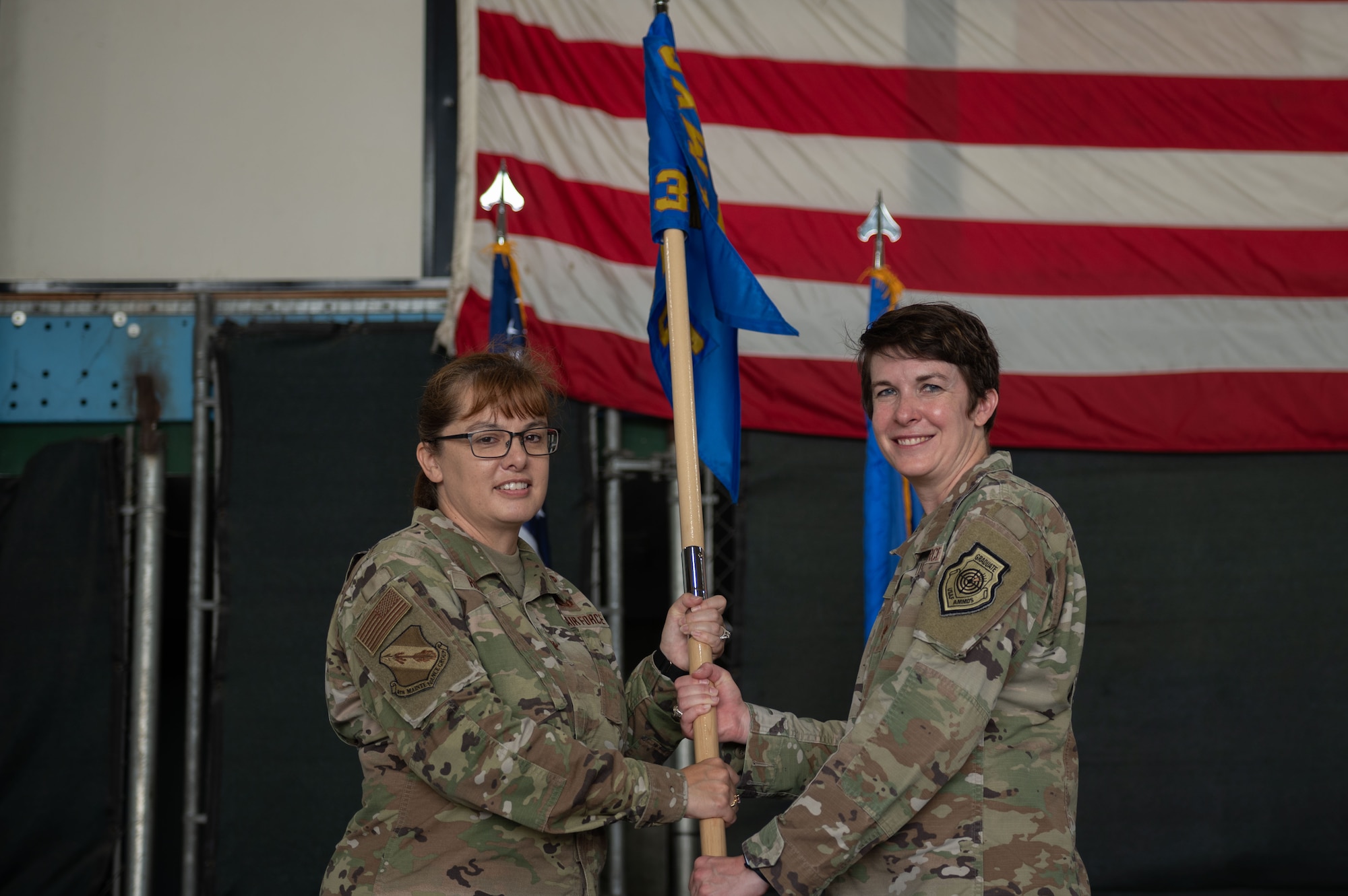 Maj. Lauren Kruse, left, incoming 333rd Fighter Generation Squadron commander, accepts the gidon of Col. Kathryn Roman, left, 4th Maintenance Group commander, during a change of command ceremony at Seymour Johnson Air Force Base, North Carolina, June 23, 2023. Base and community leadership, along with friends and family of the squadron’s incoming and outgoing commanders, gathered to witness the traditional passing of the guidon. (U.S. Air Force photo by Airman 1st Class Rebecca Sirimarco-Lang)