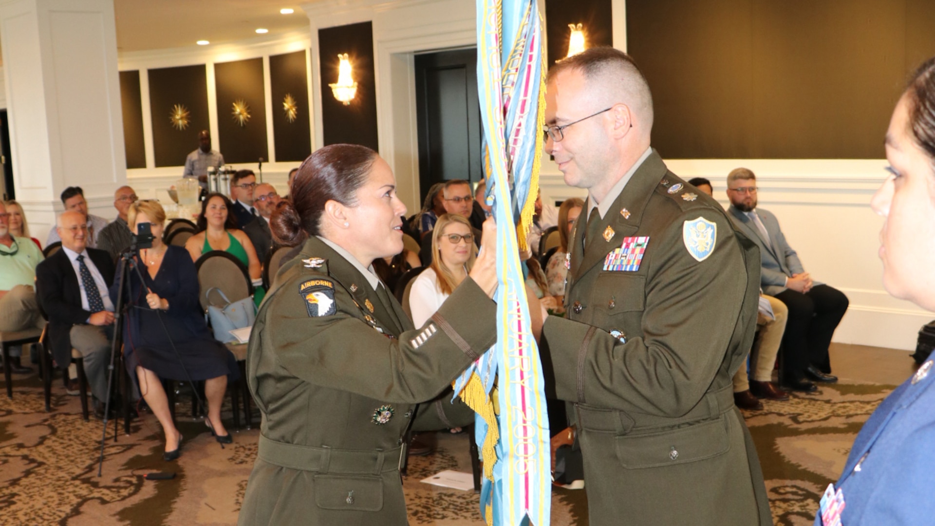 a male and female in uniform exchange the DLA flag