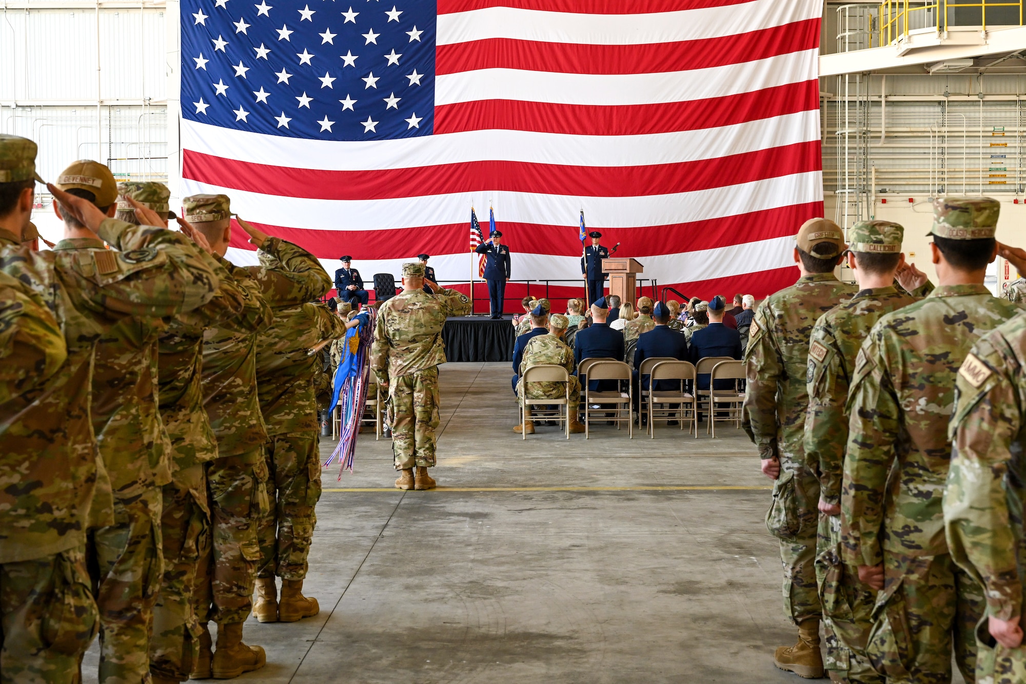The 19th Maintenance Group performs a change of command ceremony in an airplane hangar