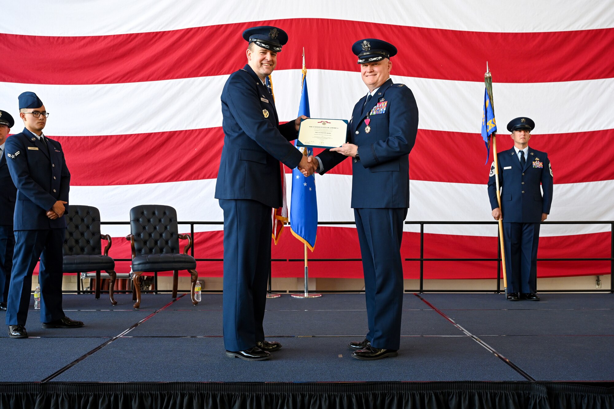 The 19th Maintenance Group performs a change of command ceremony in an airplane hangar