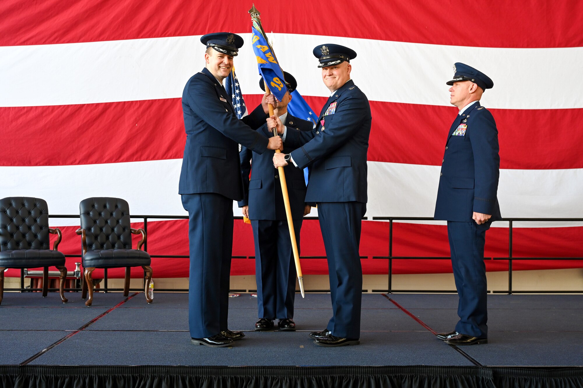 The 19th Maintenance Group performs a change of command ceremony in an airplane hangar