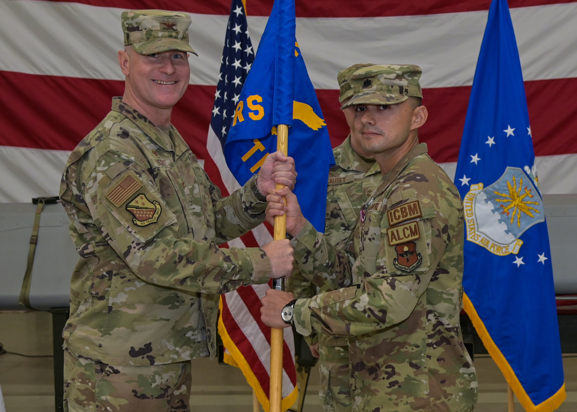 U.S. Air Force Lt. Col. Christiam Ormaza, outgoing 532nd Training Squadron commander, passes the squadron’s flag to U.S. Air Force Col. Charles Ploetz, 82nd Training Group commander, during a change of command ceremony at the 532nd Training Squadron hanger on Vandenberg Space Force Base, Calif., June 9, 2023. U.S. Air Force Lt. Col. Frank Scopa will take Ormaza's place as the new  commander. (U.S. Space Force photo by Senior Airman Rocio Romo)