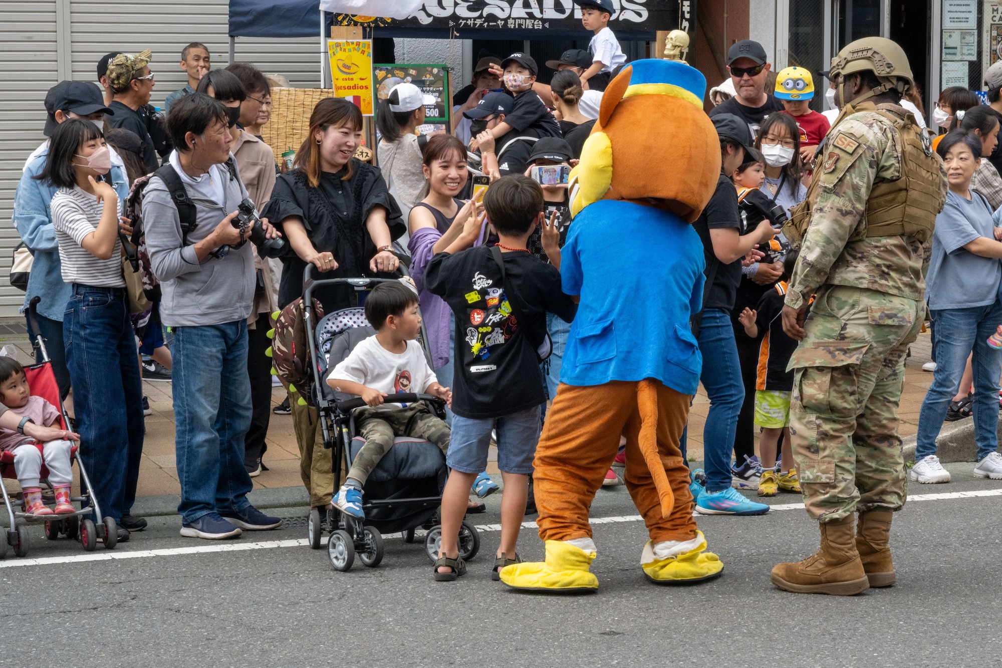 Members of 35th Security Forces Squadron pose for photos with American Day parade attendees in Misawa City, Japan, June 25, 2023. More than 50,000 attendees from across Japan traveled to Misawa City to enjoy and appreciate American and Japanese culture. (U.S. Air Force photo by Staff Sgt. Kristen Heller)