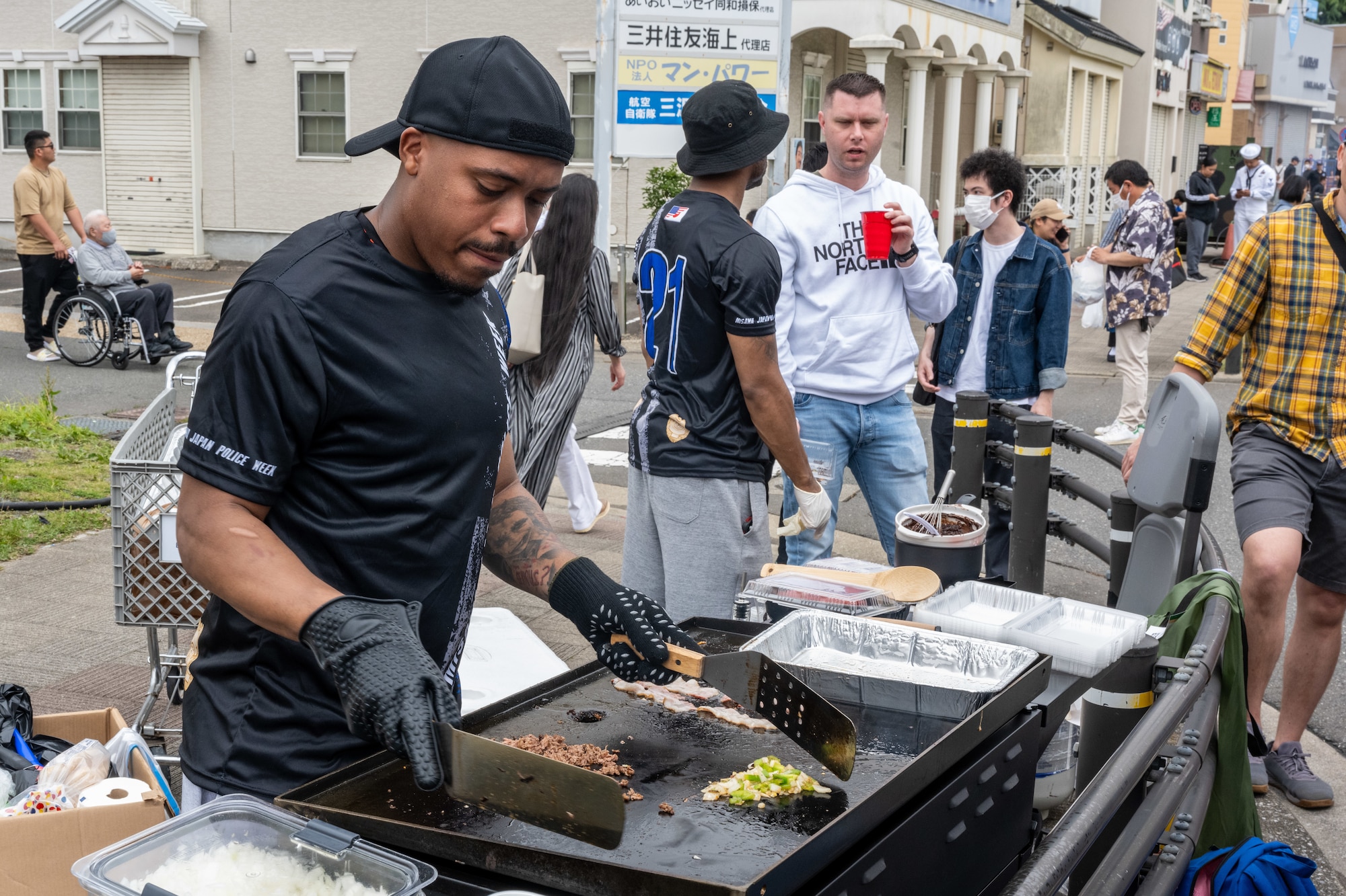 A volunteer for American Day cooks philly cheesesteaks for the crowds in Misawa City, Japan, June 25, 2023. Events like these are important as they afford Misawa’s local community, American and Japanese alike, opportunities to interact in a relaxed environment meant to build friendships and strengthen partnerships. (U.S. Air Force photo by Staff Sgt. Kristen Heller)