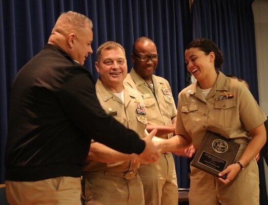 Lt. j.g. Amy Wikle received her award for earning honor graduate in her Naval Intelligence Officer Basic Course (NIOBC) from Cmdr. John Copeland, commanding officer of IWTC Virginia Beach, and Lt. Cmdr. Joseph Jones, executive officer, at the Nov. 2022 NIOBC graduation ceremony.