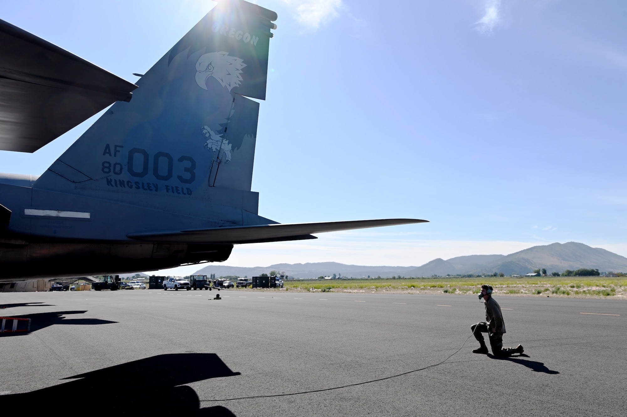 crew chief kneeling behind F-15