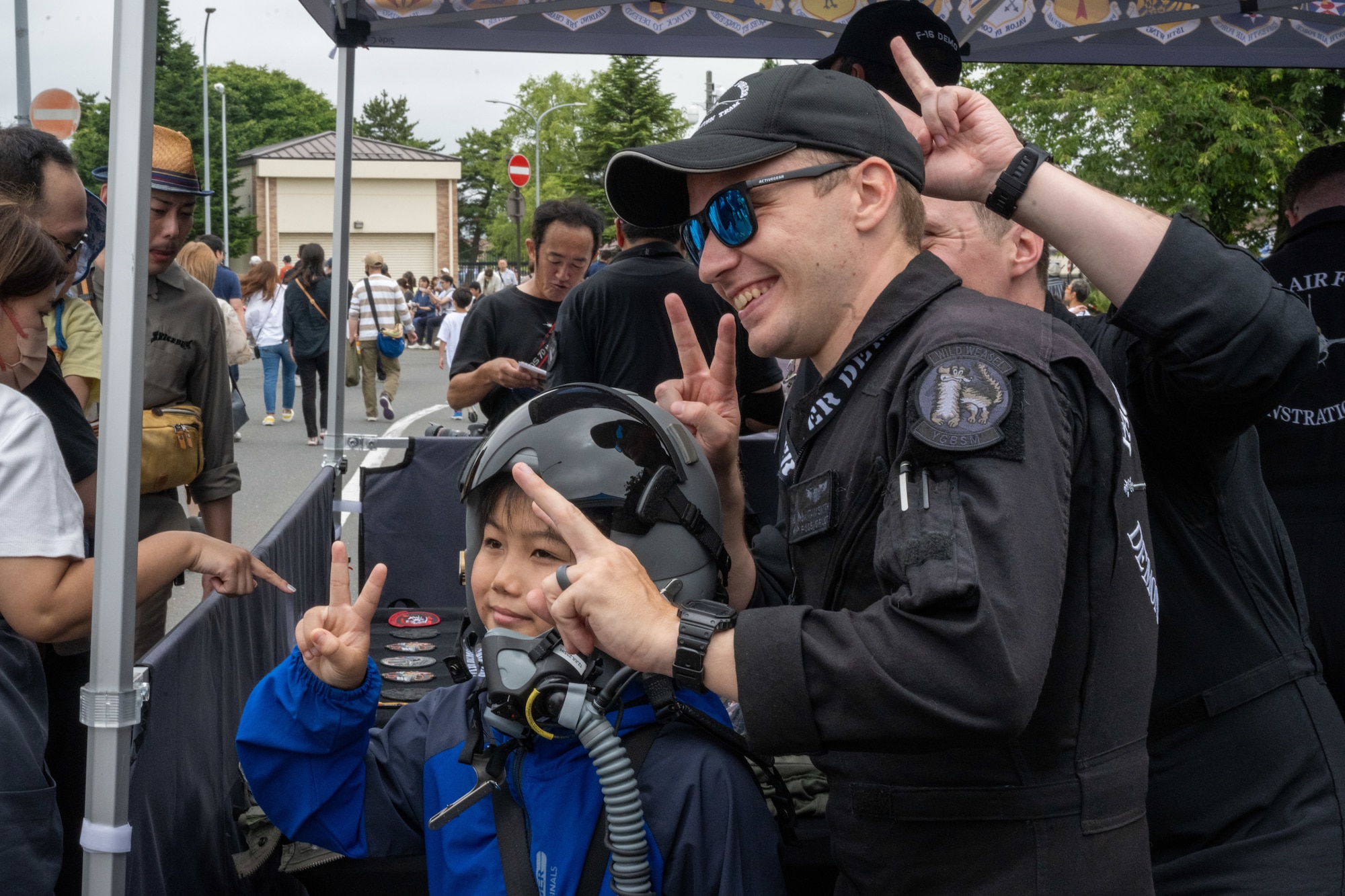 Members of the PACAF F-16 Demonstration Team pose for a photo with a Japanese attendee of American Day in Misawa City, Japan, June 25, 2023. American Day is one of the largest cross-cultural festivals in the area and it made a return after being on hiatus due to COVID-19. The event, drawing over 50,000 visitors, took on the theme “two cultures, but one community.” (U.S. Air Force photo by Staff Sgt. Kristen Heller)