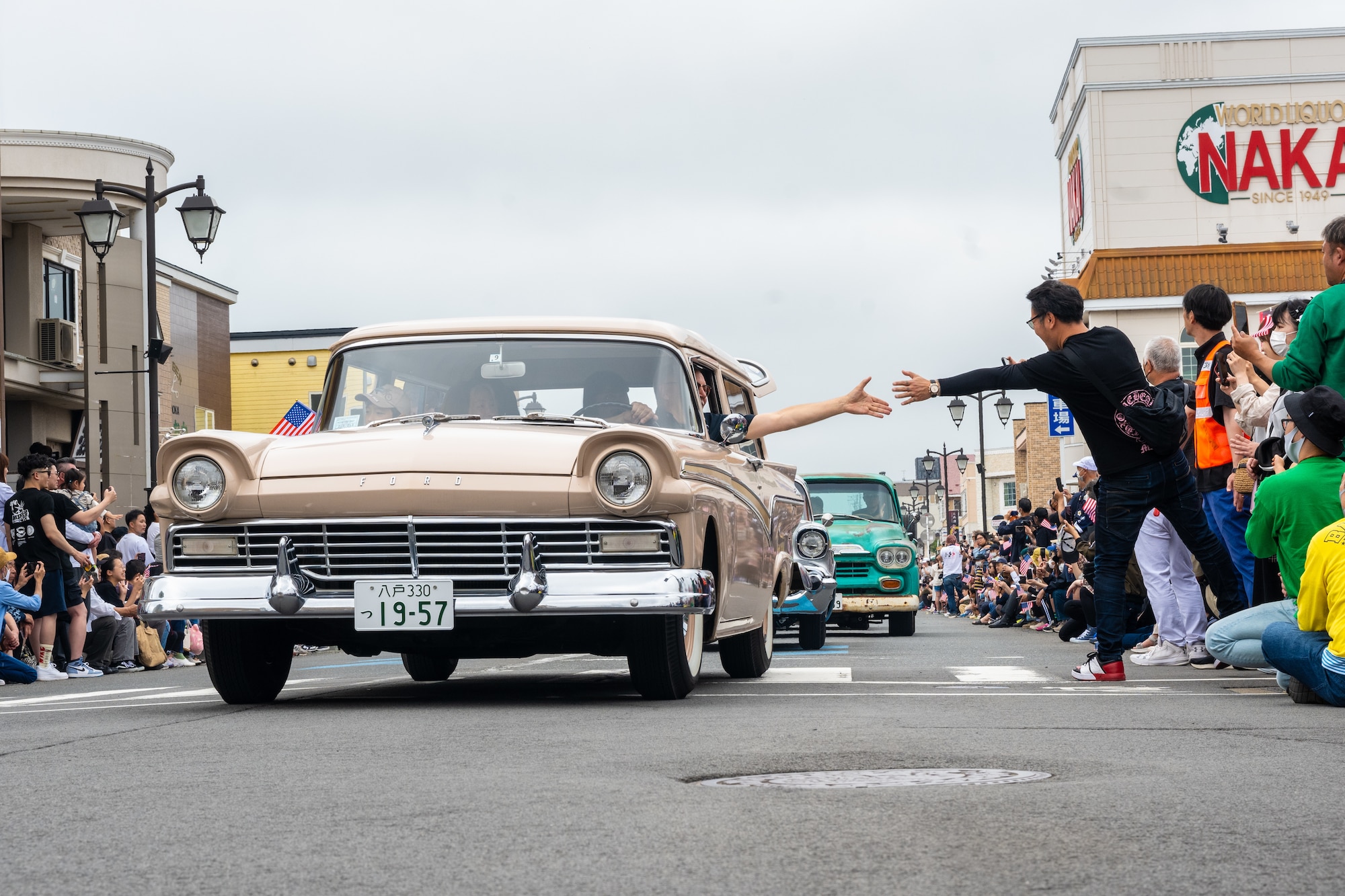 Japanese and American attendees of American Day exchange greetings during the parade in Misawa City, Japan, June 25, 2023. Events like these are important as they afford Misawa’s local community, American and Japanese alike, opportunities to interact in a relaxed environment meant to build friendships and strengthen partnerships. (U.S. Air Force photo by Staff Sgt. Kristen Heller)
