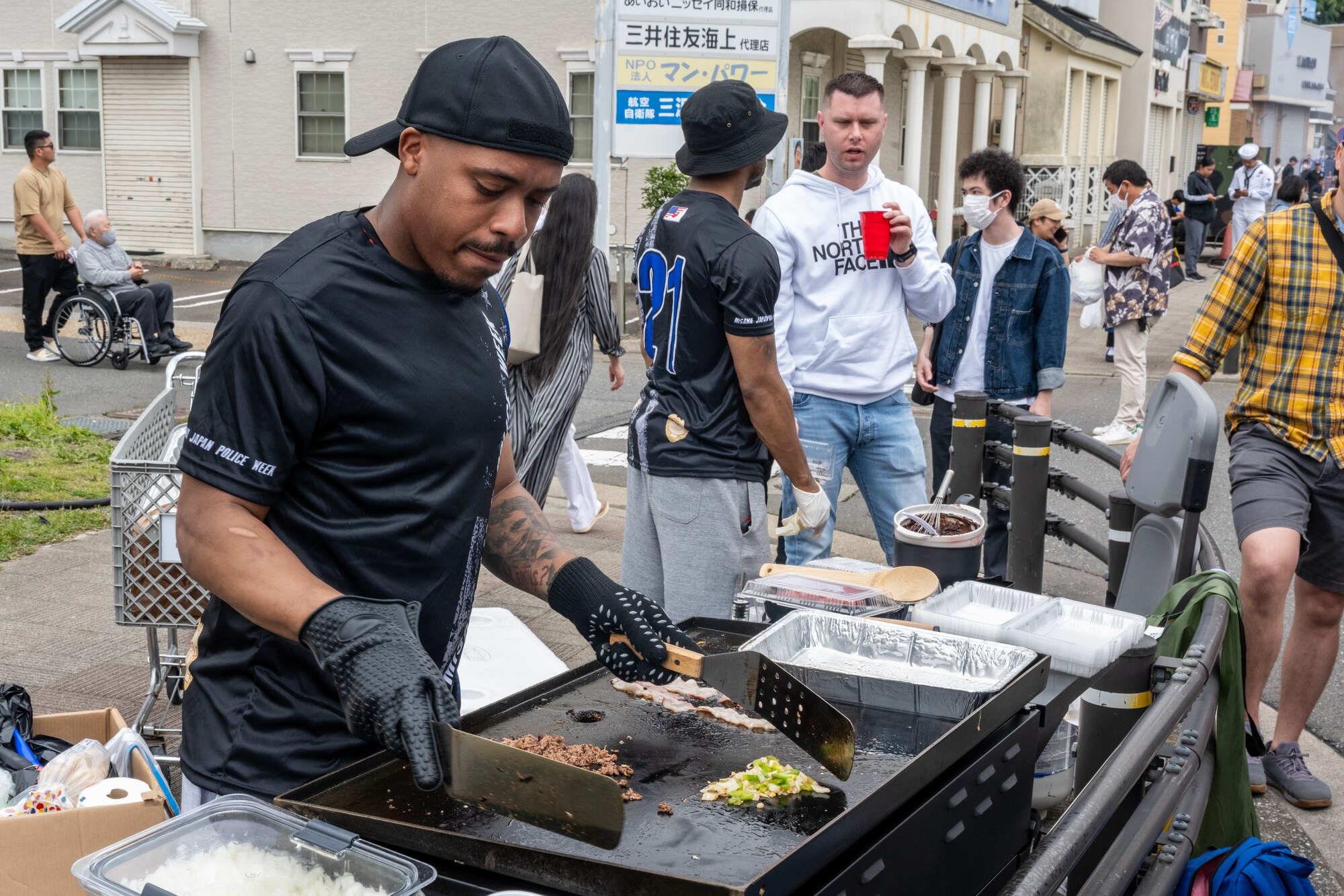A volunteer for American Day cooks philly cheesesteaks for the crowds in Misawa City, Japan, June 25, 2023. Events like these are important as they afford Misawa’s local community, American and Japanese alike, opportunities to interact in a relaxed environment meant to build friendships and strengthen partnerships. (U.S. Air Force photo by Staff Sgt. Kristen Heller)