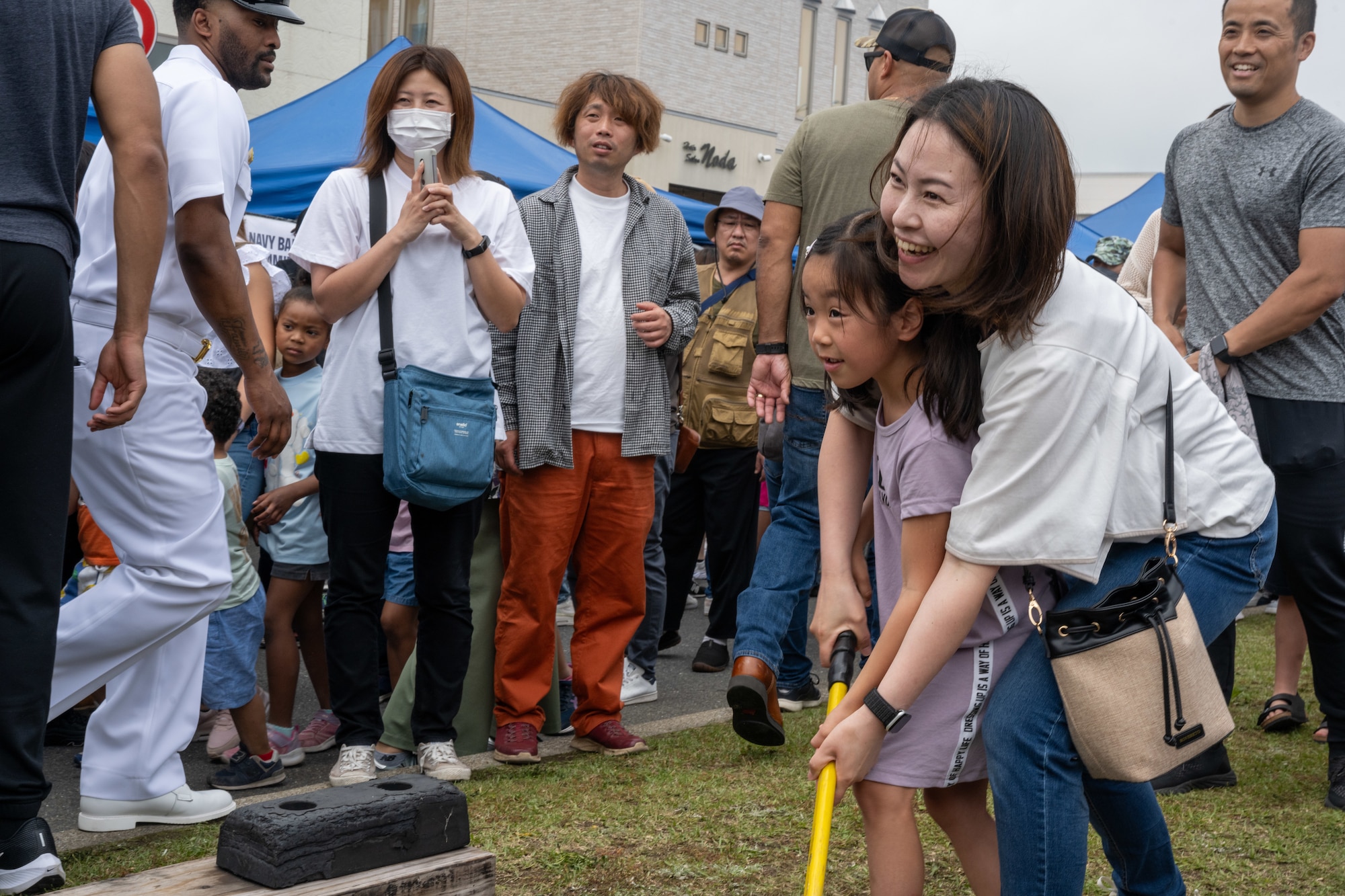 A Japanese mother and her daughter enjoy playing high striker during American Day in Misawa City, Japan, June 25, 2023. Events like these are important as they afford Misawa’s local community, American and Japanese alike, opportunities to interact in a relaxed environment meant to build friendships and strengthen partnerships. (U.S. Air Force photo by Staff Sgt. Kristen Heller)