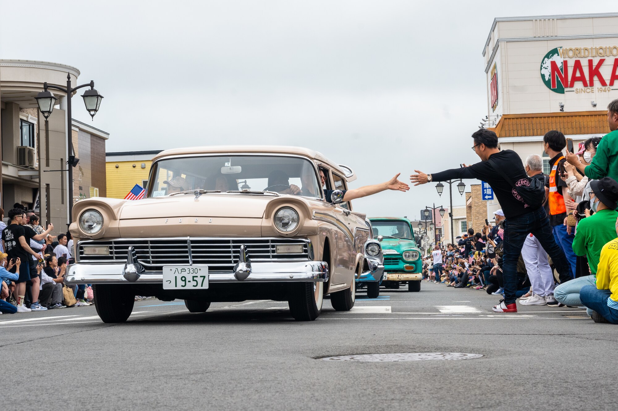 Japanese and American attendees of American Day exchange greetings during the parade in Misawa City, Japan, June 25, 2023. Events like these are important as they afford Misawa’s local community, American and Japanese alike, opportunities to interact in a relaxed environment meant to build friendships and strengthen partnerships. (U.S. Air Force photo by Staff Sgt. Kristen Heller)