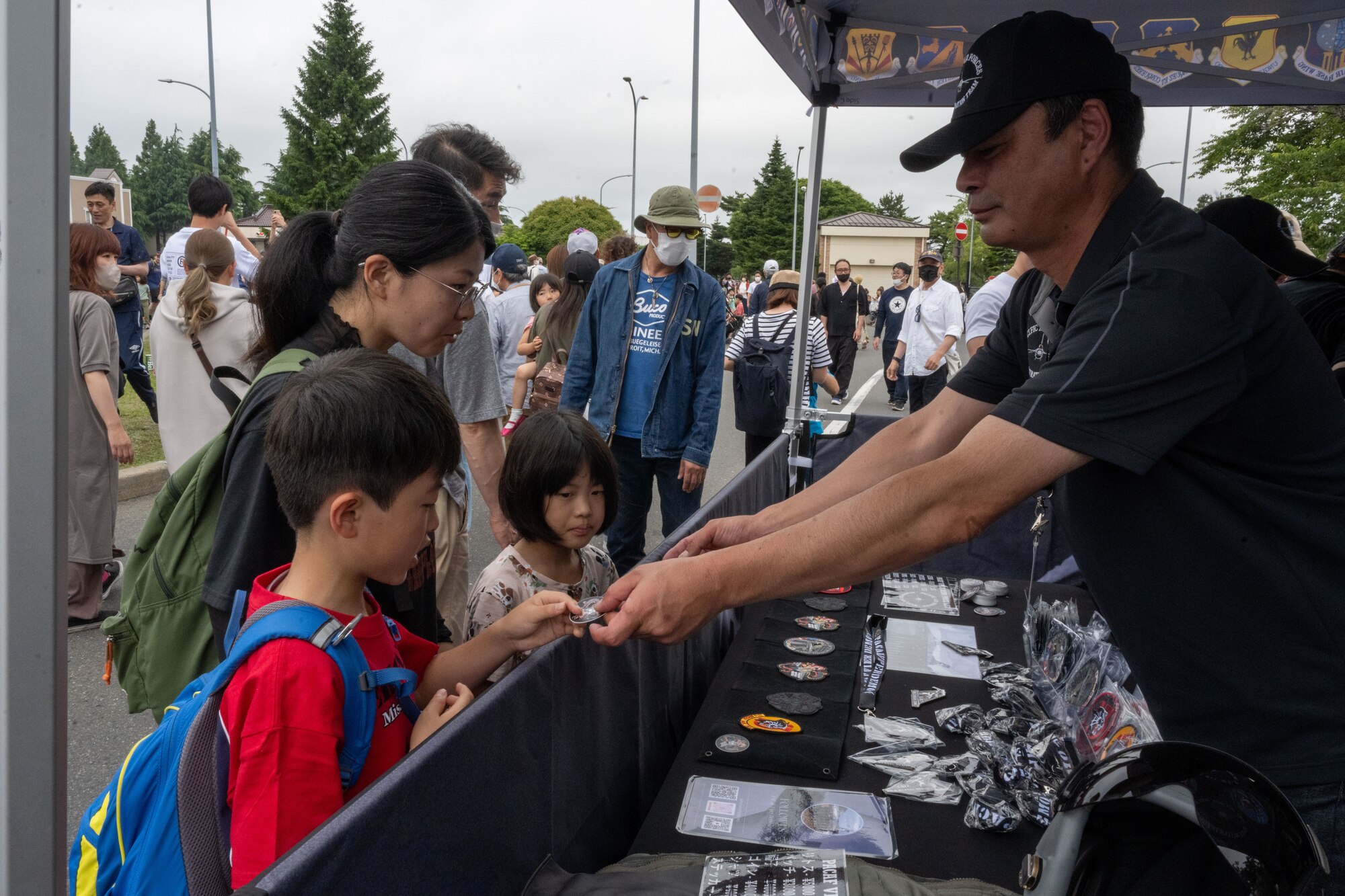 PACAF F-16 Demonstration Team stickers are handed out to attendees of American Day in Misawa City, Japan, June 25, 2023. American Day is one of the largest cross-cultural festivals in the area and it made a return after being on hiatus due to COVID-19. The event, drawing over 50,000 visitors, took on the theme “two cultures, but one community.” (U.S. Air Force photo by Staff Sgt. Kristen Heller)