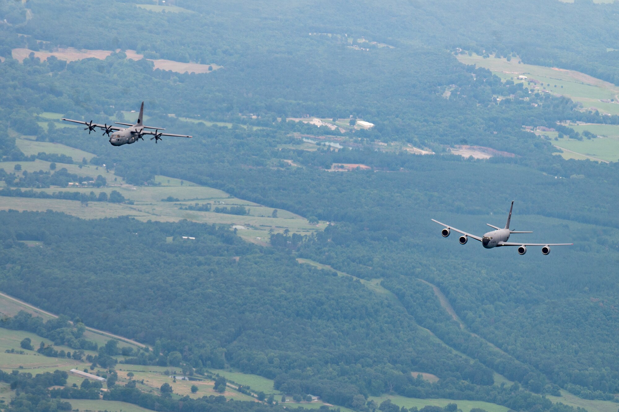 Two C-130J Super Hercules from the 19th Airlift Wing fly alongside a KC-135R from Key Field Air National Guard Bas, Mississippi, over Arkansas