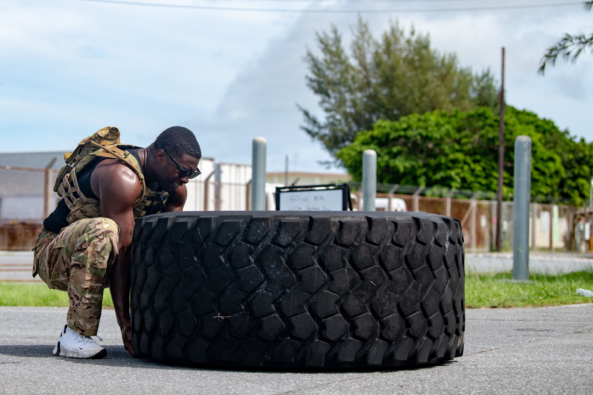 Man attempts to lift a big tire.