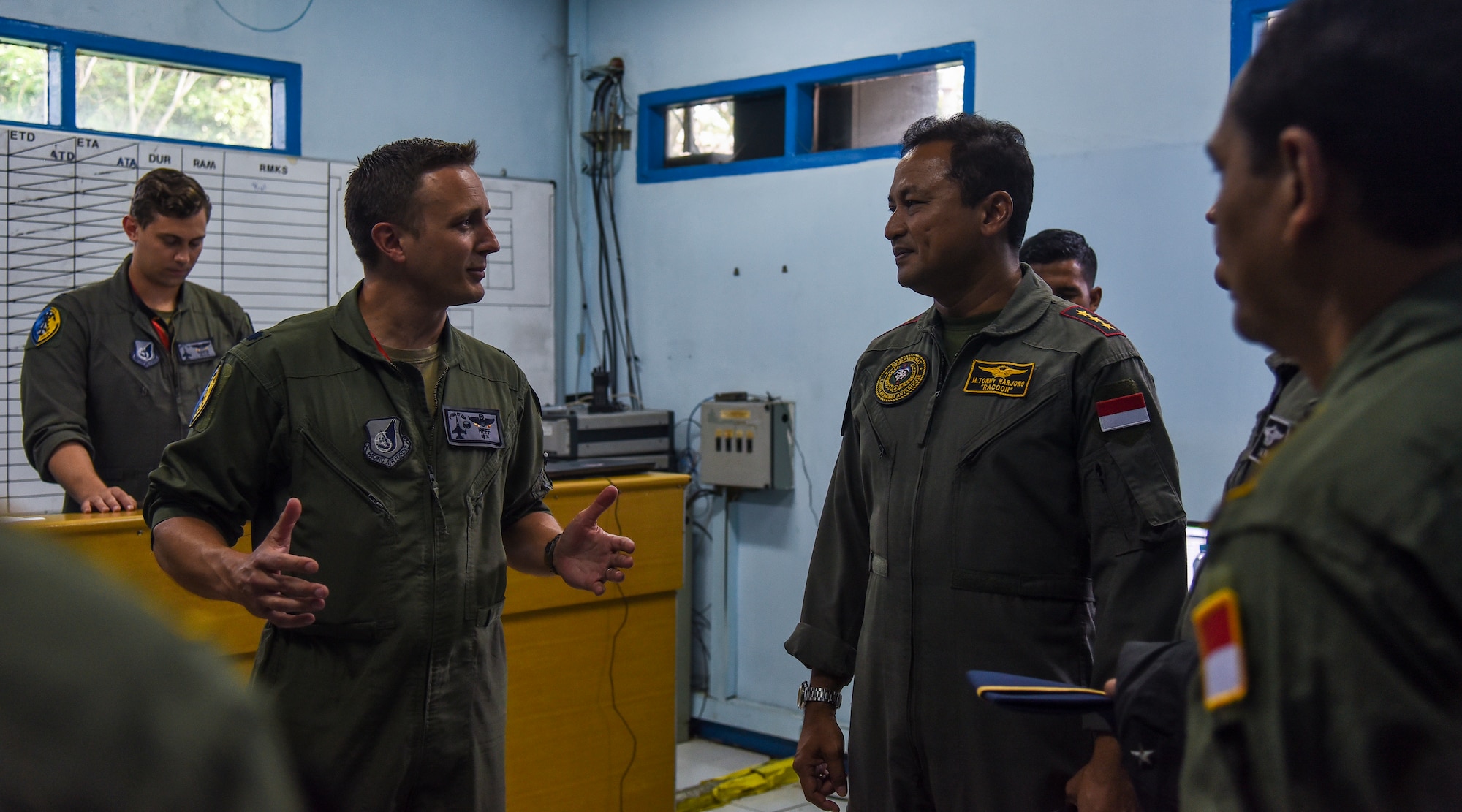 Two pilots talk in a mission planning room