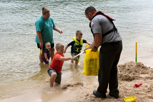 Park Ranger Bradley Potts hands out water safety goodies to kids recreating at Cordell Hull Lake's Defeated Creek Recreation Area June 24, 2023, to encourage them to stay safe when swimming. Park rangers at U.S. Army Corps of Engineers Nashville District lakes made 155,187 public contacts, conducted 1,431 vessel inspections, and supported more than 200 public outreach events in 2022 in support of water safety initiatives. (USACE Photo by Lee Roberts)