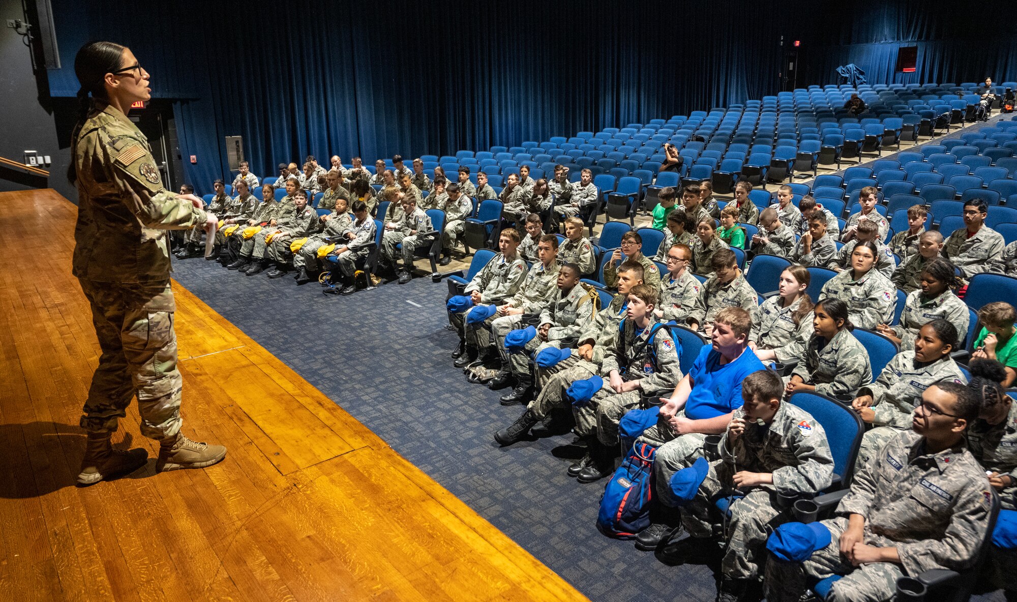 A female Airman speaks to Civil Air Patrol cadets in an auditorium