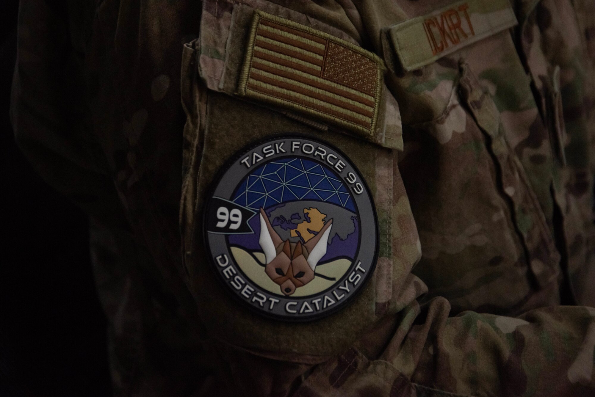 A U.S. Air Force Academy cadet wears a Task Force 99 patch at Al Udeid Air Base, Qatar, June 22, 2023. The cadets participated in research and innovation at TF 99 as part of the academy’s Cadet Summer Research Program (CSRP). TF 99 is the cornerstone of Ninth Air Force (AFCENT)’s approach to U.S. Central Command’s intent of building a Culture of Innovation by using commercial and government off-the-shelf technology and partnering with Academia, Industry, and coalition members in order to solve operational problem sets. (U.S. Air Force photo by Staff Sgt. Jennifer Zima)