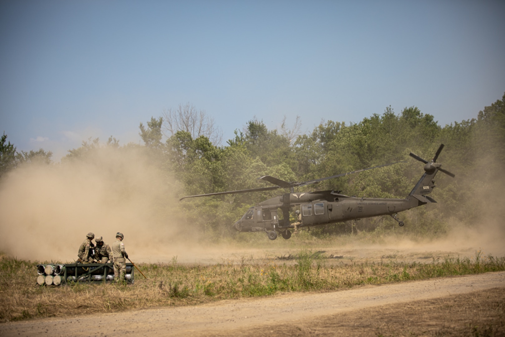 Soldiers with the 45th Field Artillery Brigade, Oklahoma Army National Guard, prepare for sling load training alongside members of Charlie Company, 1st Battalion, 244th Aviation Regiment, 90th Troop Command, during exercise Western Strike at Fort Chaffee, Arkansas, June 22, 2023. Western Strike is a highly immersive and fully instrumented training comparable to a combat training center that aims to prepare units like the 45th FAB for overseas operations. (Oklahoma National Guard photo by Spc. Danielle Rayon)