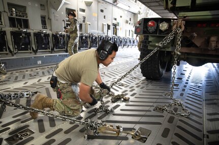Senior Airman Kevin Lim, member of the 97th Air Mobility Wing, secures a High Mobility Artillery Rocket System (HIMARS) inside of a C-17 aircraft in preparation for transport at the Lawton-Fort Sill Regional Airport June 14, 2023. The Soldiers were loading the HIMARS into C-17 aircraft assigned to the 97th Air Mobility Wing out of Altus Air Force Base as part of a joint exercise to practice the Soldiers’ and Airmen’s skills to rapidly and safely transport the launchers and equipment across large distances. (Oklahoma Army National Guard photo by Spc. Caleb Stone)