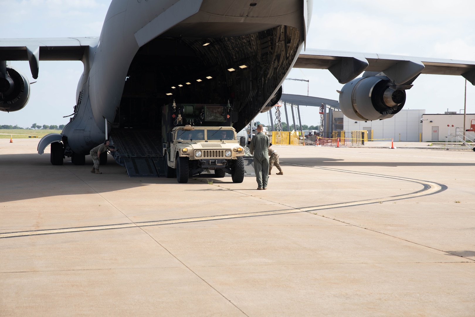 Oklahoma Army National Guard Soldiers with 1st Battalion,158th Field Artillery Regiment, 45th Field Artillery Brigade, load a Humvee carrying a Fire Direction Center onto a C-17 aircraft in preparation for transport at the Lawton-Fort Sill Regional Airport June 14, 2023. The Soldiers were loading the HIMARS into C-17 aircraft assigned to the 97th Air Mobility Wing out of Altus Air Force Base as part of a joint exercise to practice the Soldiers’ and Airmen’s skills to rapidly and safely transport the launchers and equipment across large distances. (Oklahoma Army National Guard photo by Spc. Caleb Stone)