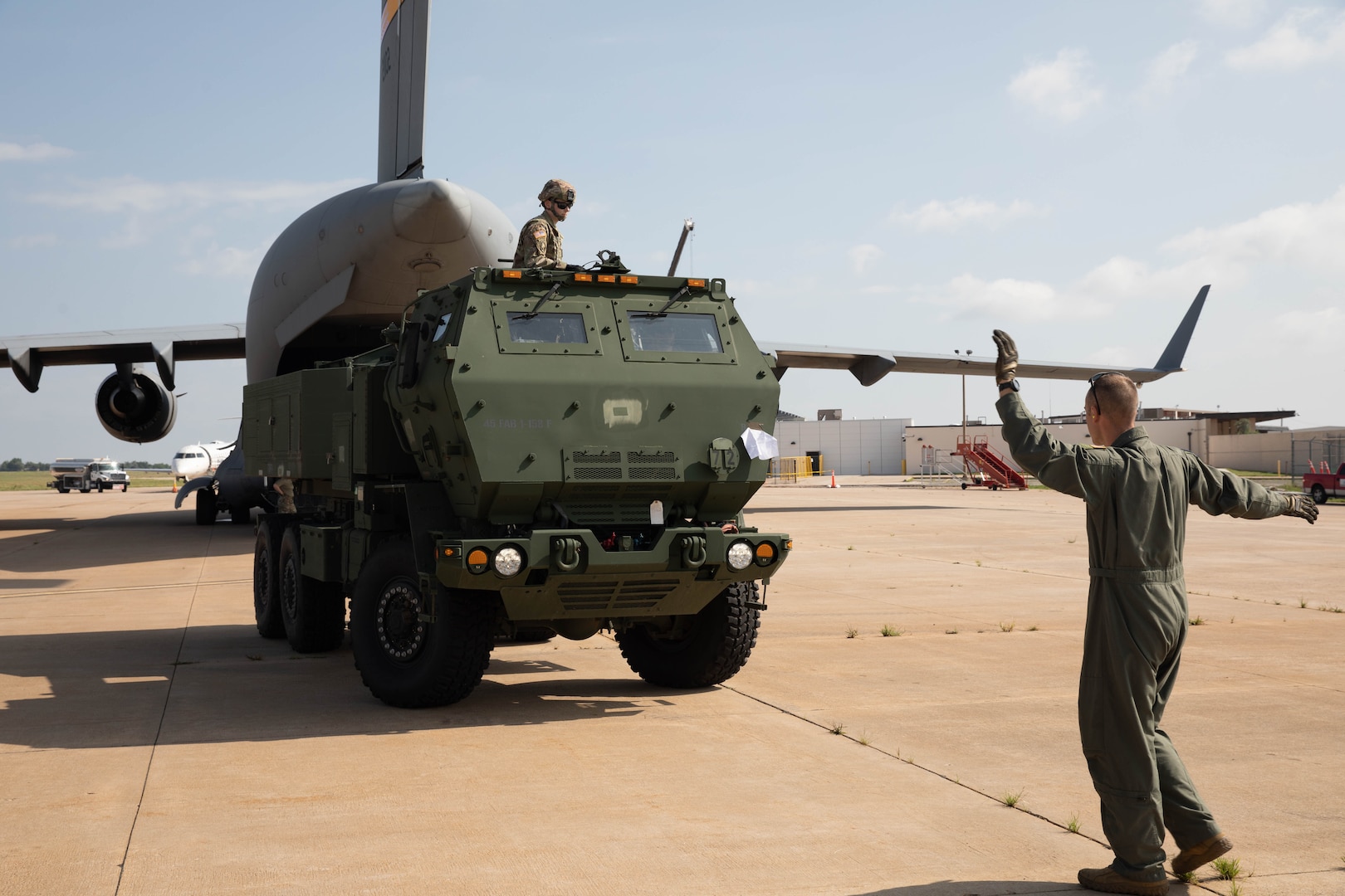 Oklahoma Army National Guard Soldiers with 1st Battalion, 158th Field Artillery Regiment, 45th Field Artillery Brigade, back a High Mobility Artillery Rocket System (HIMARS) into a C-17 aircraft in preparation for transport at the Lawton-Fort Sill Regional Airport June 14, 2023. The Soldiers were loading the HIMARS into C-17 aircraft assigned to the 97th Air Mobility Wing out of Altus Air Force Base as part of a joint exercise to practice the Soldiers’ and Airmen’s skills to rapidly and safely transport the launchers and equipment across large distances. (Oklahoma Army National Guard photo by Spc. Caleb Stone)