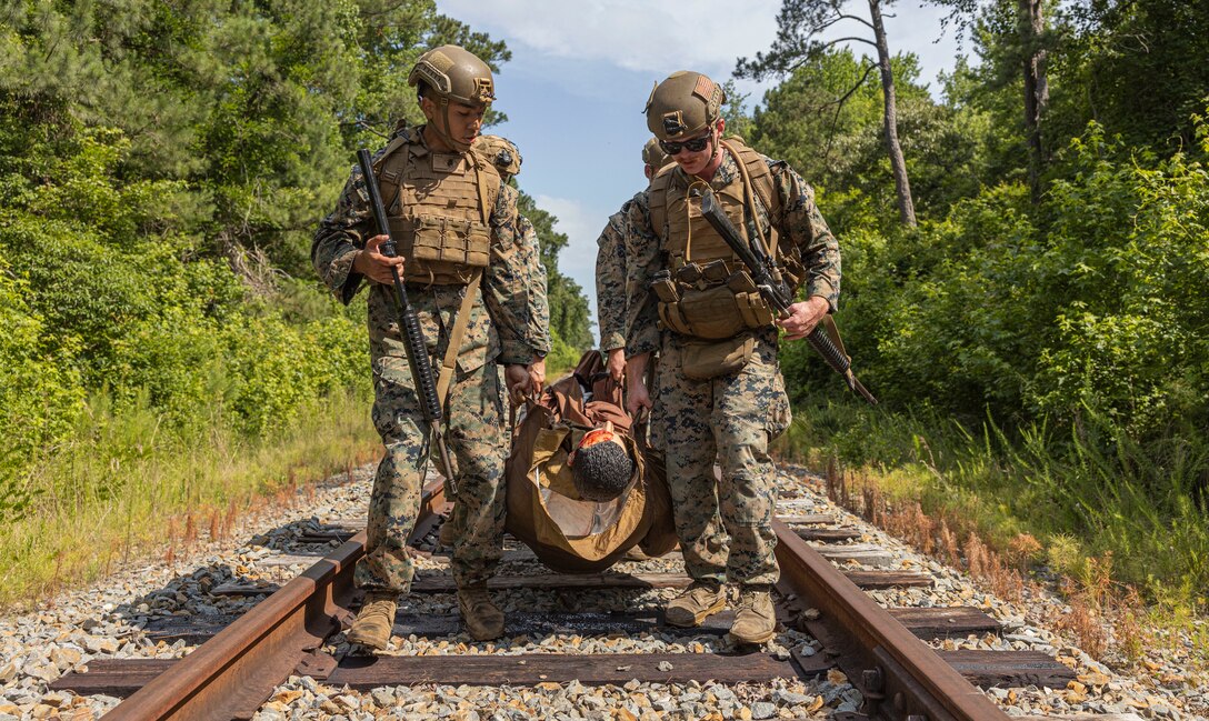 U.S. Navy Corpsman and Marines with 2d Marine Division, transport a patient during a Doc Kent competition on Camp Lejeune, North Carolina, June 15, 2023. The competition showcases the capabilities of executing tactical combat casualty care in austere environments by utilizing various evacuation platforms to move from point of injury to higher echelons of care. (U.S. Marine Corps photo by Cpl. Megan Ozaki)