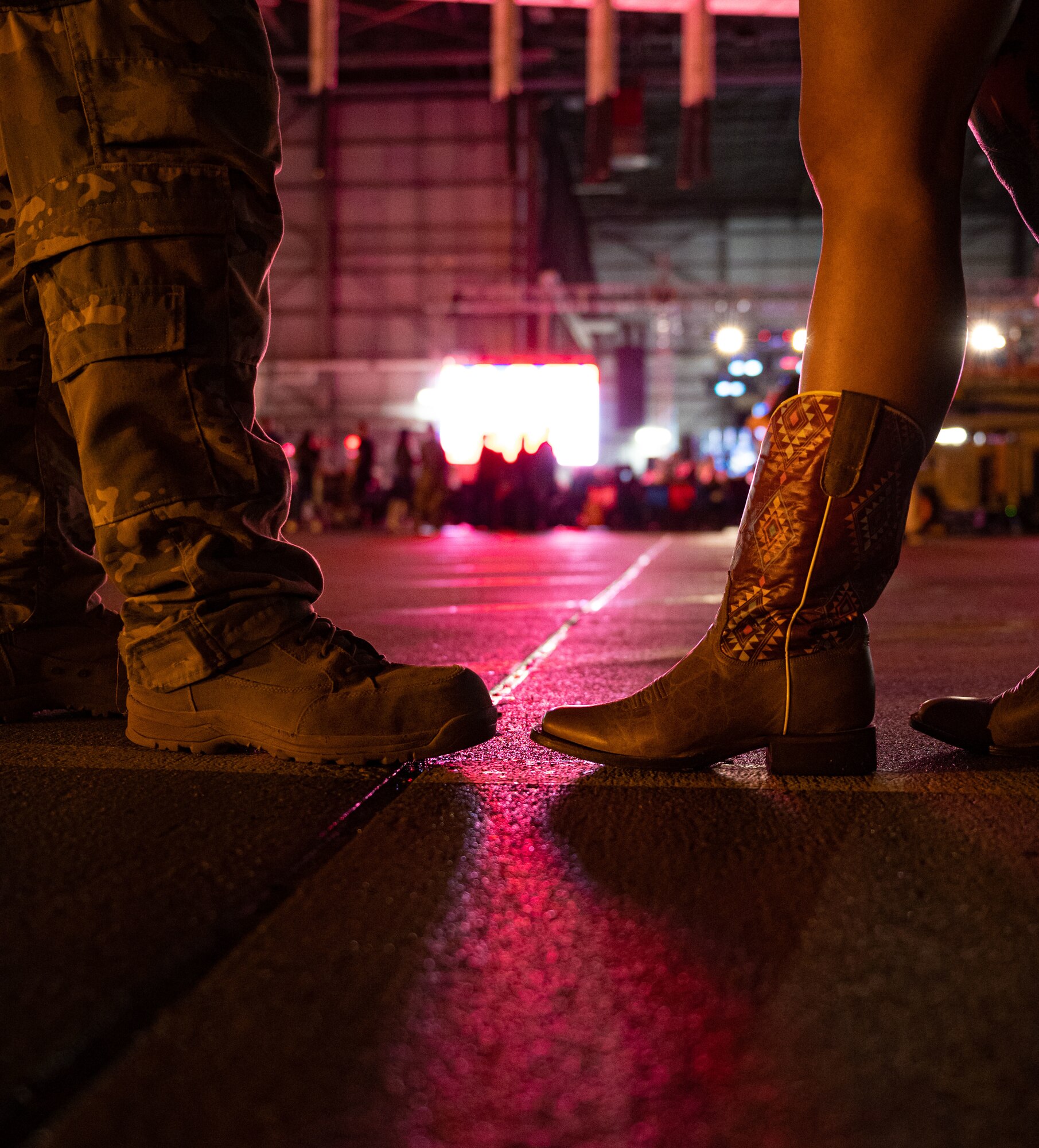 An Air Force member in combat boots and a country music fan in western boots observe the Freedom Fest concert at Dover Air Force Base, Delaware, June 22, 2023. Freedom Fest, hosted by Air Force Entertainment Live Stage, was free to Department of Defense card holders and featured opening act Ryan Daniel, support act Lonestar and headliner Rodney Atkins. (U.S. Air Force photo by Airman 1st Class Amanda Jett)