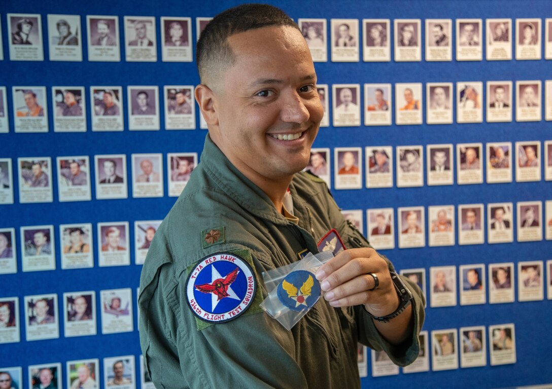 Maj. Bryce Turner, 416th Flight Test Squadron, became the first Air Force pilot to fly the T-7A Red Hawk, following a test flight at the Boeing aircraft delivery center in St. Louis, Missouri, June 28. Turner holds up a patch that once belonged to John L. Hamilton of the 99th Fighter Squadron, the Tuskegee Airmen. Hamilton was the first pilot in his squadron to receive the Purple Heart.