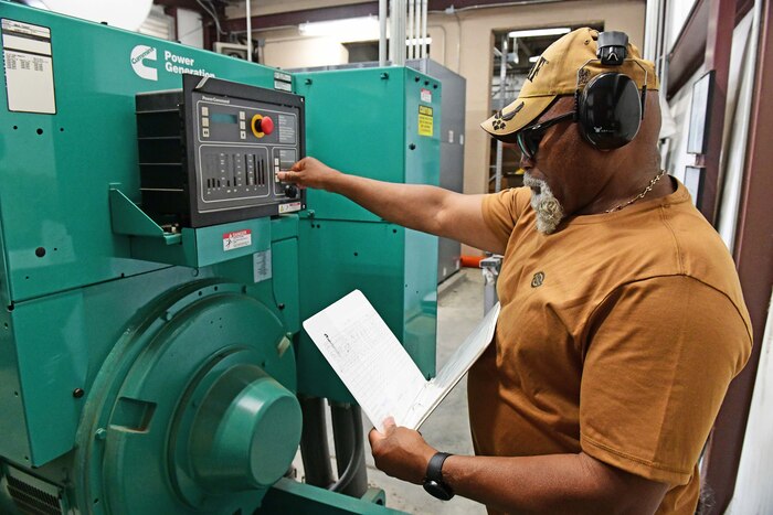 Man standing next to a generator