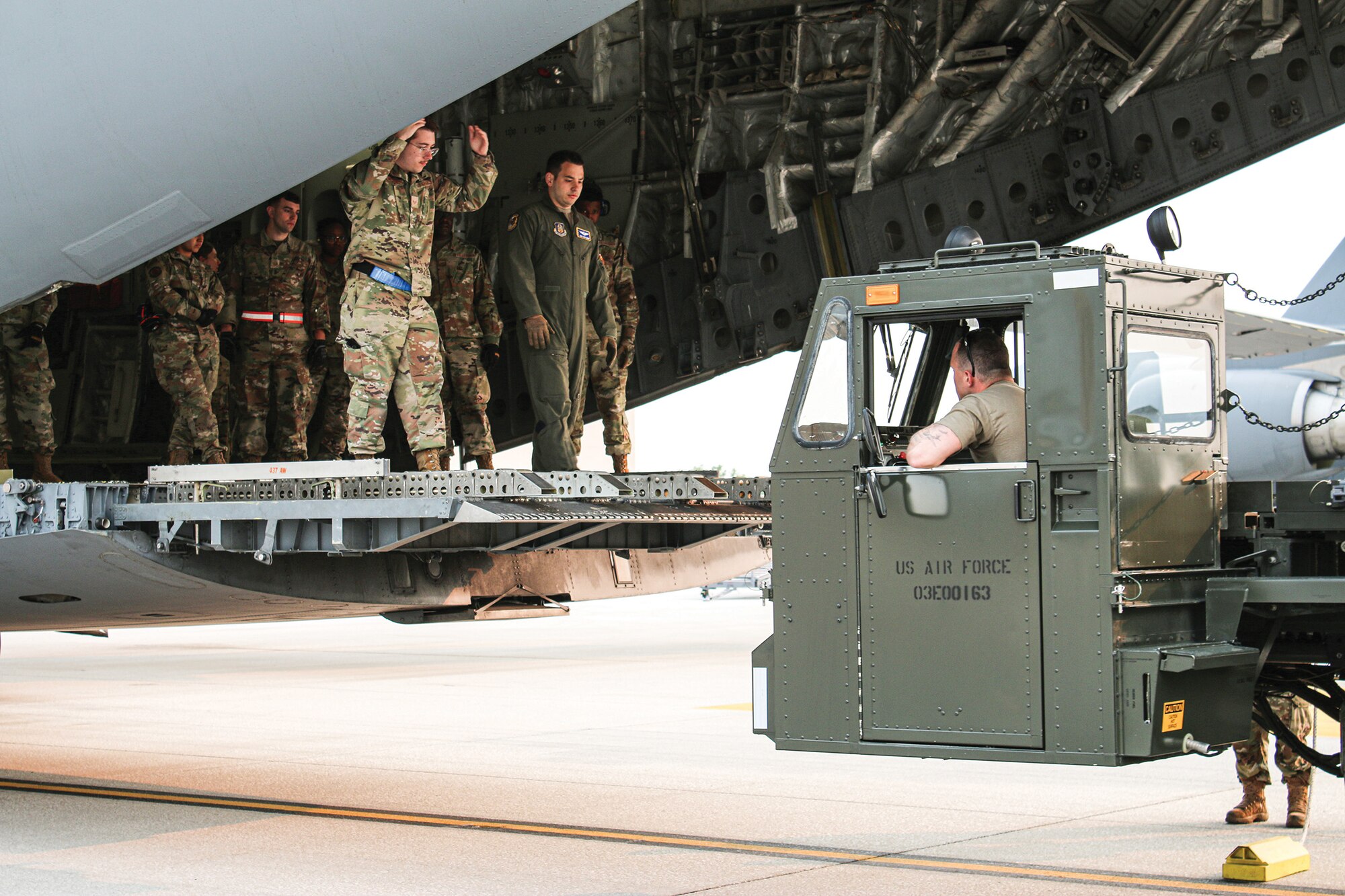 Airmen from the 87th Aerial Port Squadron position a Tunner 60K-loader to the rear of a C-17 Globemaster III aircraft to load cargo during training on the flightline at Wright-Patterson Air Force Base, June 4, 2023. Airmen from the 445th Aircraft Maintenance Squadron, 89th Airlift Squadron and 87th APS train together.
