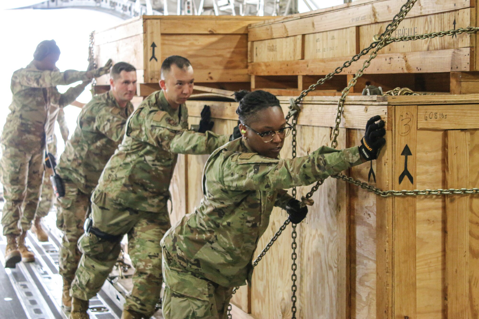 Airmen from the 87th Aerial Port Squadron push a T3 pallet load from a Tunner 60K-Loader to the inside of a C-17 Globemaster III aircraft during training June 4, 2023, on the flightline at Wright-Patterson AFB. Airmen with the 89th Airlift Squadron, 445th Aircraft Maintenance Squadron and 87th APS trained together on the flightline using two C-17 statics as their training site.
