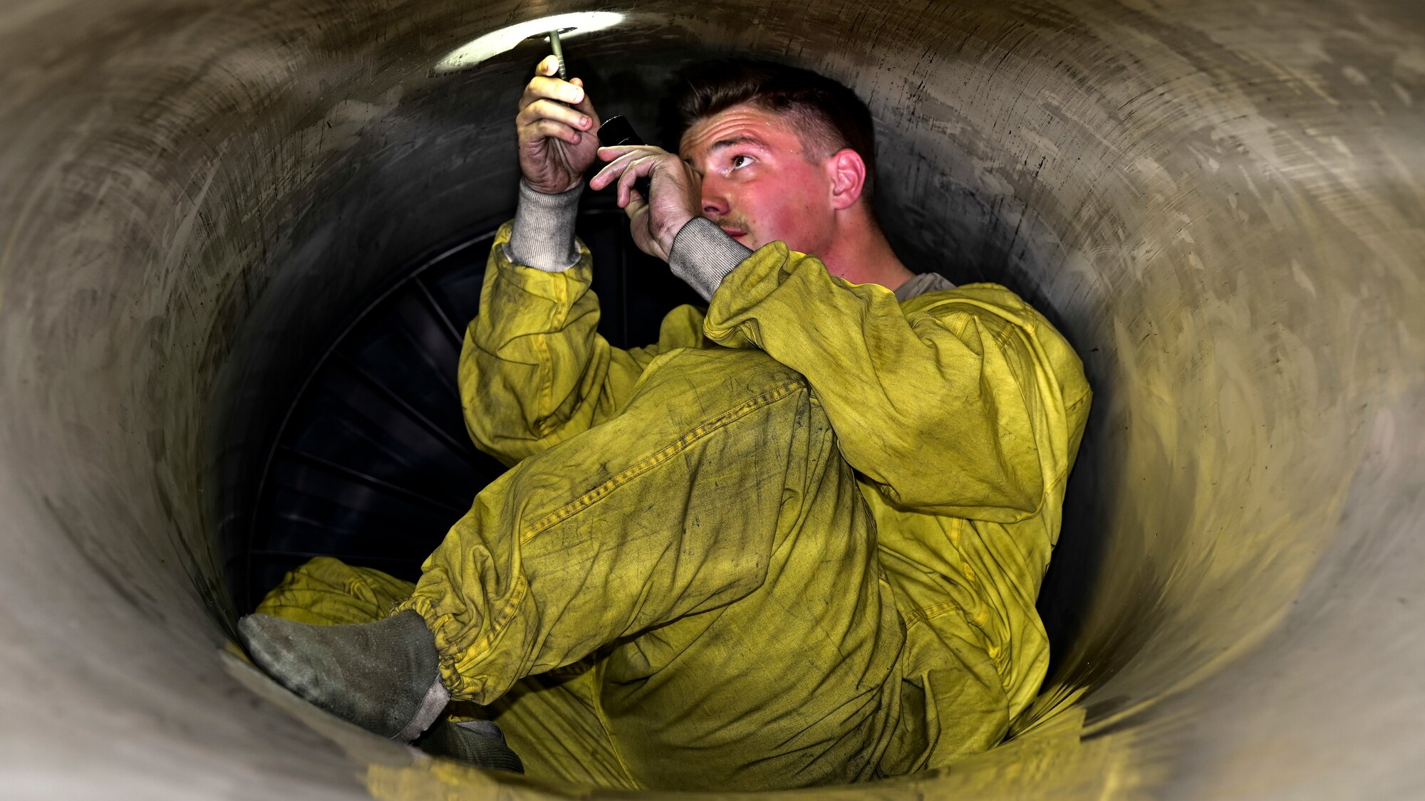 U.S. Air Force Senior Airman William Domnick, 849th Aircraft Maintenance Squadron assistant dedicated crew chief, inspects the exhaust port of an F-16 Viper at Holloman Air Force Base, New Mexico, June 27, 2023.