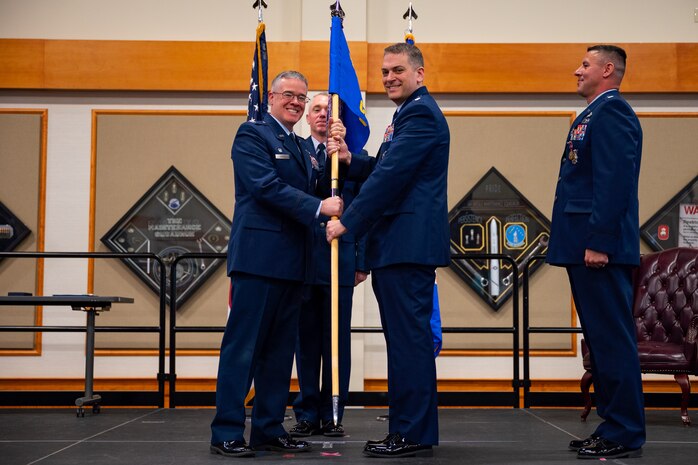 Photo of commanders holding flag.