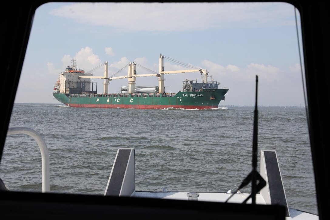 The cargo container marine vessel PAC Seginus steams north with a cargo of wind turbine blades in the Houston Shipping Channel as the crew of the USACE Galveston District survey boat Tanner II waits for the ship to pass.