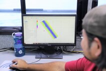 Jasper Schaer, U.S. Army Corps of Engineers Galveston District, Hydro Survey Team, observes a Houston Shipping Channel map after completing a post dredge survey aboard the Tanner II survey vessel. Single beam sonar was used for this survey because this version uses lower frequency sound than multi-beam sonar. The lower frequency gives better measurements through the fluff or fine sediment at the bottom of the Houston Shipping Channel.
