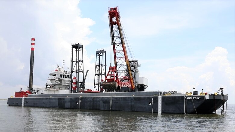 The DB Avalon, one of the largest clamshell dredges in North America, drops a 30 cubic yard load of dredge material onto the Sand Point barge, in the Houston Shipping Channel.