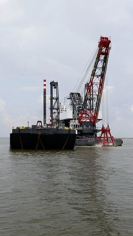 The DB Avalon, one of the largest clamshell dredges in North America, drops a 30 cubic yard load of dredge material onto the Sand Point barge, in the Houston Shipping Channel.