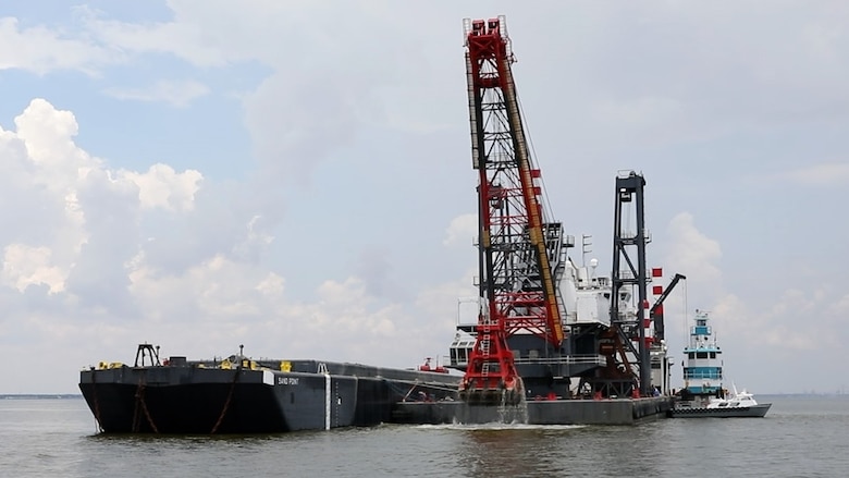 The DB Avalon, one of the largest clamshell dredges in North America, drops a 30 cubic yard load of dredge material onto the Sand Point barge, in the Houston Shipping Channel.