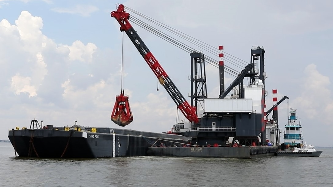 The DB Avalon, one of the largest clamshell dredges in North America, drops a 30 cubic yard load of dredge material onto the Sand Point barge, in the Houston Shipping Channel.