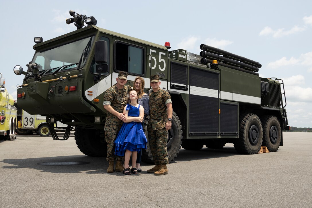 U.S. Marine Corps Master Sgt. Christopher Lisle, left, a regional expeditionary firefighting and rescue chief with Marine Aircraft Control Group-28, poses for a photo with his family after his retirement ceremony at Marine Corps Air Station Cherry Point, North Carolina, June 16, 2023. After a 23-year career, Lisle's legacy will be carried on by his son, Lance Cpl. Devin Lisle, an aircraft rescue and firefighting specialist with Headquarters and Headquarters Squadron 751.