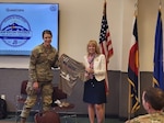 U.S. Air Force Col. Carrie Worrell shows off a t-shirt promoting the Colorado National Guard’s first ever Joint Resiliency Directorate (J9) to a room full of CONG members May 6, 2023. CONG J9 was established Dec. 1, 2022, under the direction of the National Defense Authorization Act 2022 and the Independent Review Commission appointed by U.S. President Joe Biden. (Photo courtesy CONG J9)