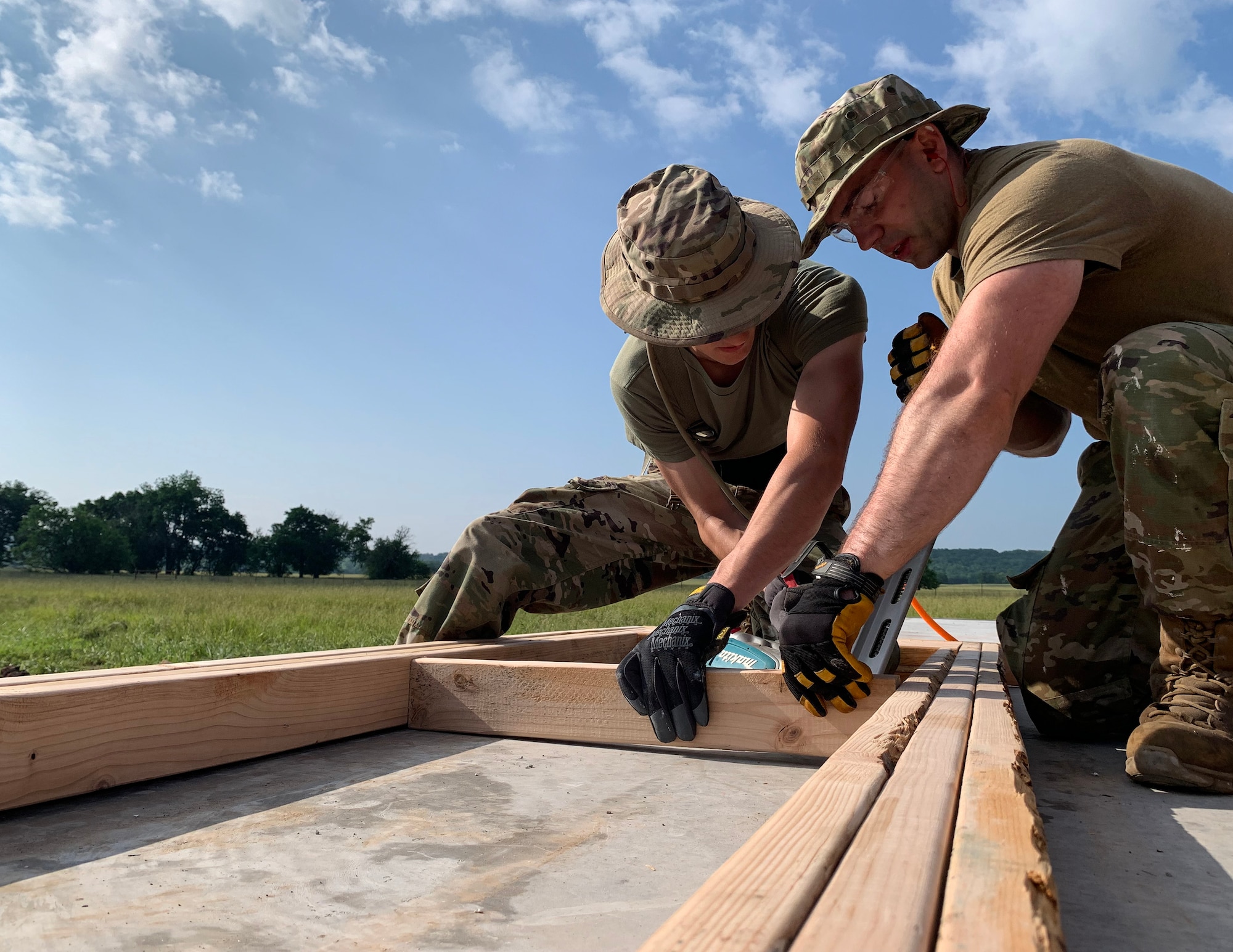 U.S. Air Force Senior Airman Mitchell Krogell and Airman 1st Class Travis Schmitt prepare framing for a new house in Tahlequah, Olka., May 22, 2023.