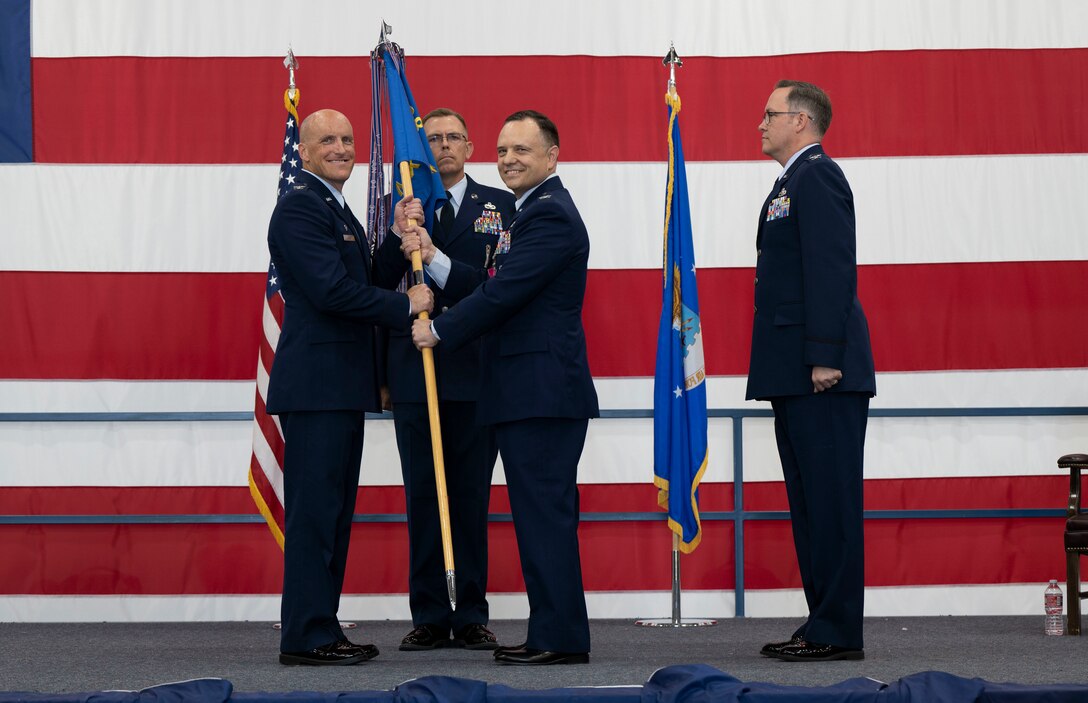 U.S. Air Force Col. Derek Oakley, 28th Bomb Wing commander, left, accepts the 28th Maintenance Group guidon from Col. Nathan Mitchell, outgoing 28th MXG commander at Ellsworth Air Force Base, South Dakota, June 29, 2023.