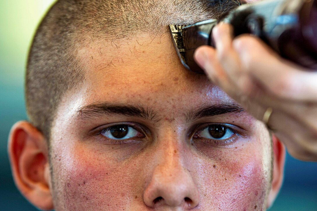 A close-up of a cadet getting a haircut.