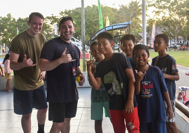 Airmen pose with children at a sports day