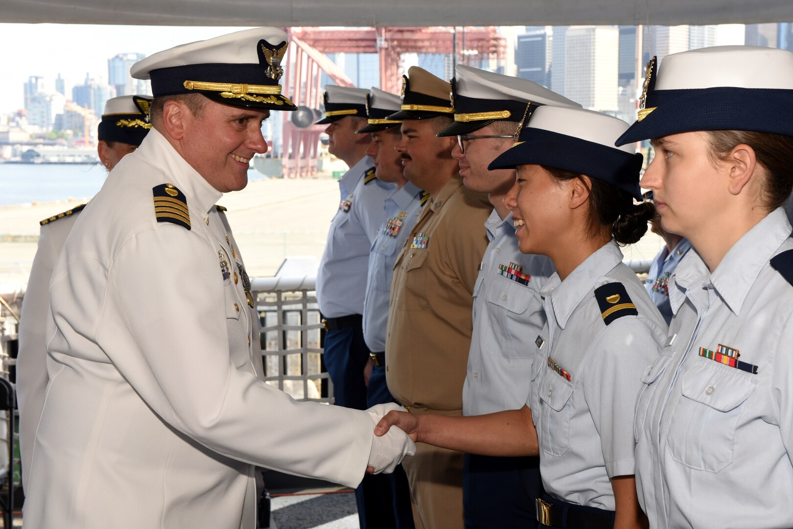 Capt. Kenneth Boda, commanding officer of Coast Guard Cutter Healy (WAGB 20) shakes hands with a member of the crew while conducting an inspection during a change of command ceremony aboard Healy, June 29, 2023, at Base Seattle. Capt. Michele Schallip relieved Boda as commanding officer and will assume command, beginning her fifth tour afloat. (U.S. Coast Guard photo by Petty Officer 2nd Class Michael Clark)