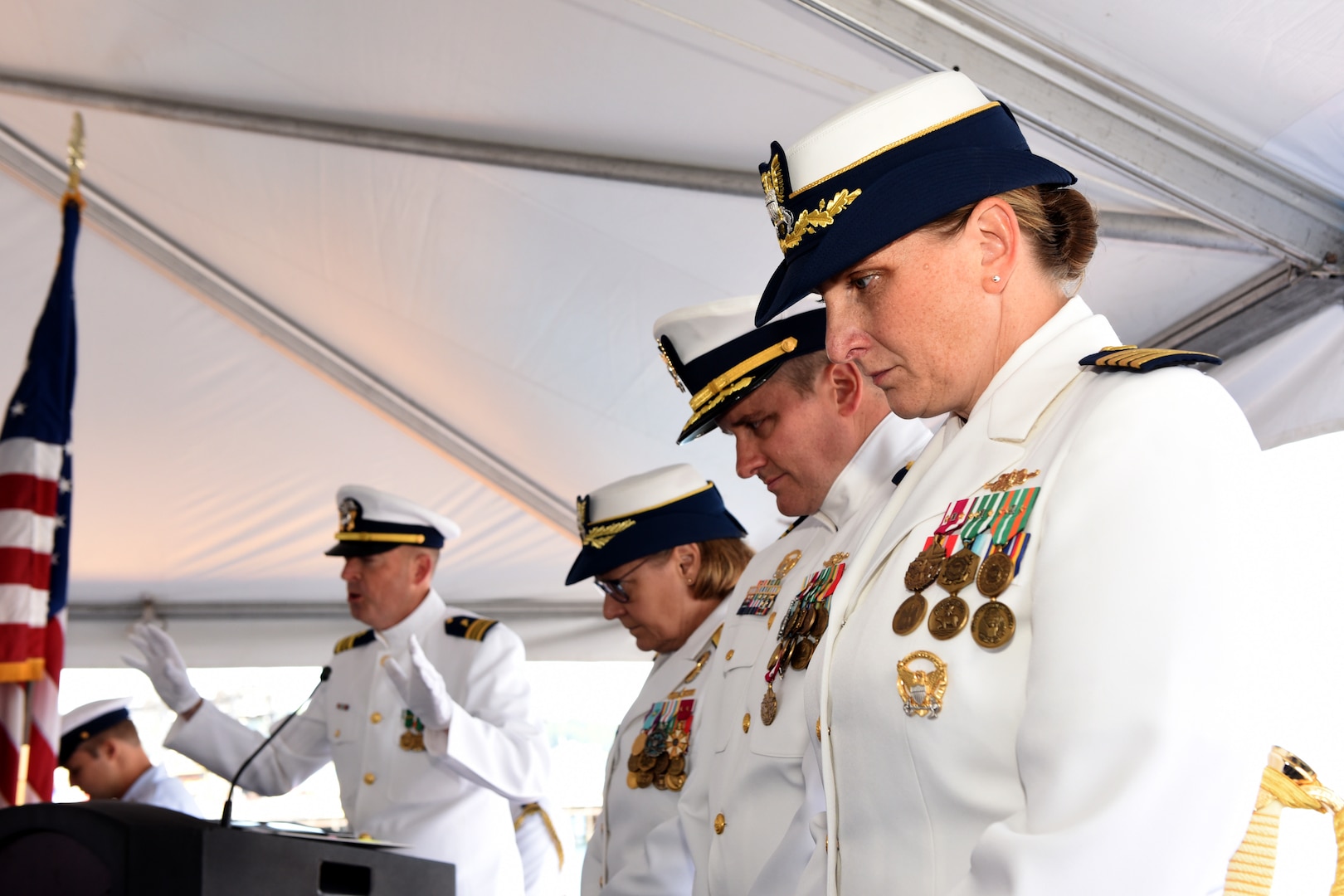 Capt. Michele Schallip bows her head in prayer, alongside Capt. Kenneth Boda and Adm. Linda Fagan, commandant of the U.S. Coast Guard, during the benediction and conclusion of a change of command ceremony held aboard Coast Guard Cutter Healy (WAGB 20), June 29, 2023, at Base Seattle. During the ceremony, Schallip officially assumed command of Healy, relieving Boda. (U.S. Coast Guard photo by Petty Officer 2nd Class Michael Clark)