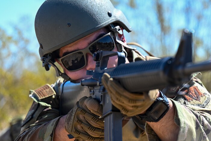 A photo of a man wearing a military uniform and helmet firing a rifle.