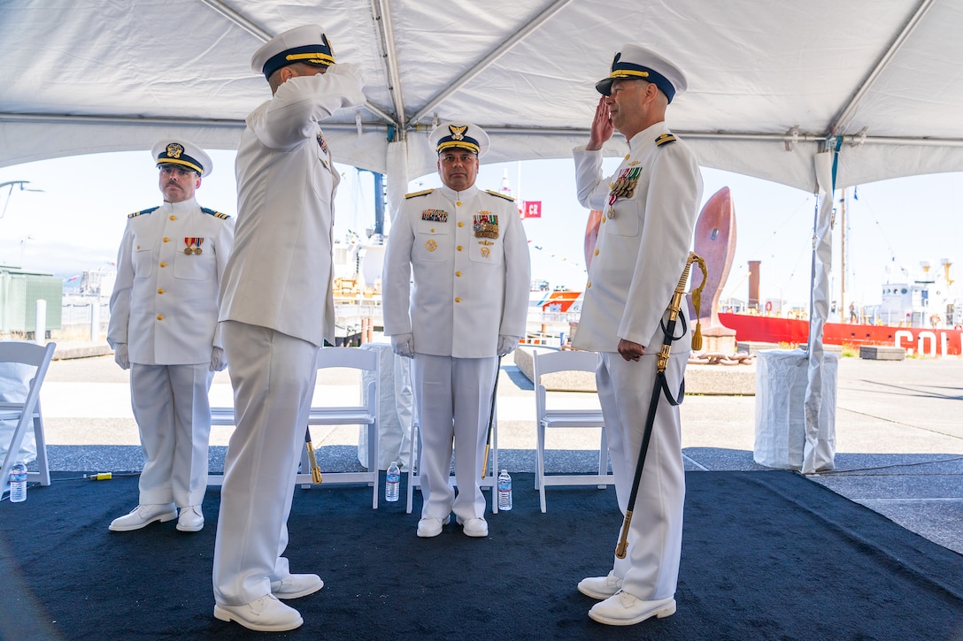 Cmdr. Lee Crusius, the commanding officer of Coast Guard Cutter Alert (WMEC 630), salutes Cmdr. Matthew Kolodica during Alert's change of command ceremony in Astoria, Oregon, June 29, 2023. During the ceremony, Crusius relieved Kolodica as the cutter’s commanding officer. (U.S. Coast Guard photo by Petty Officer 1st Class Travis Magee)